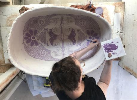 一位妇女正在画一件陶瓷艺术品